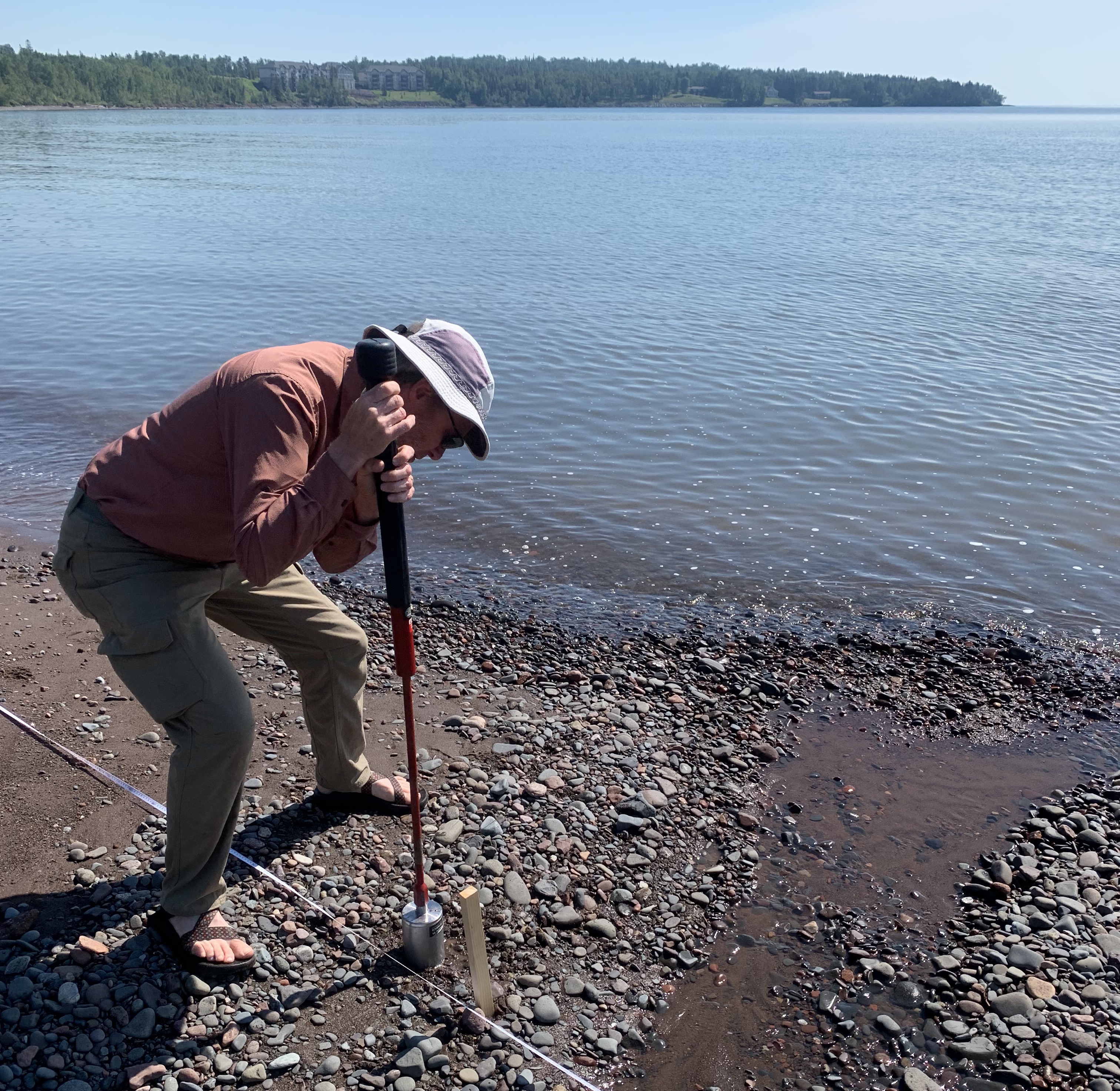 Collecting sediment core on a Lake Superior beach.